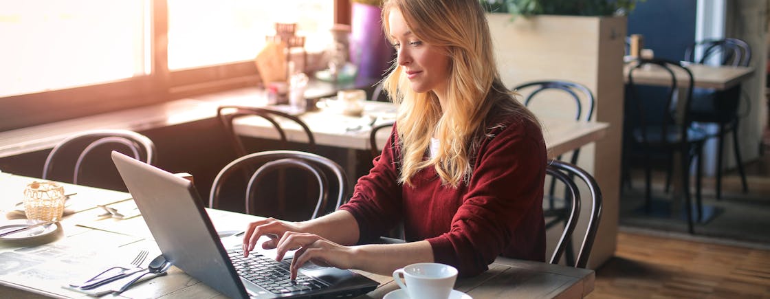 Vrouw in koffietent met laptop