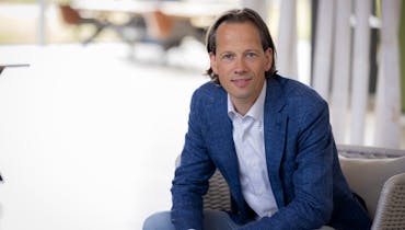 Christian Klein, inkomensadviseur, zit op een stoel. Hij vertelt u wat eigenrisicodrager zijn kan betekenen.