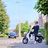 Jongen op stilstaande scooter