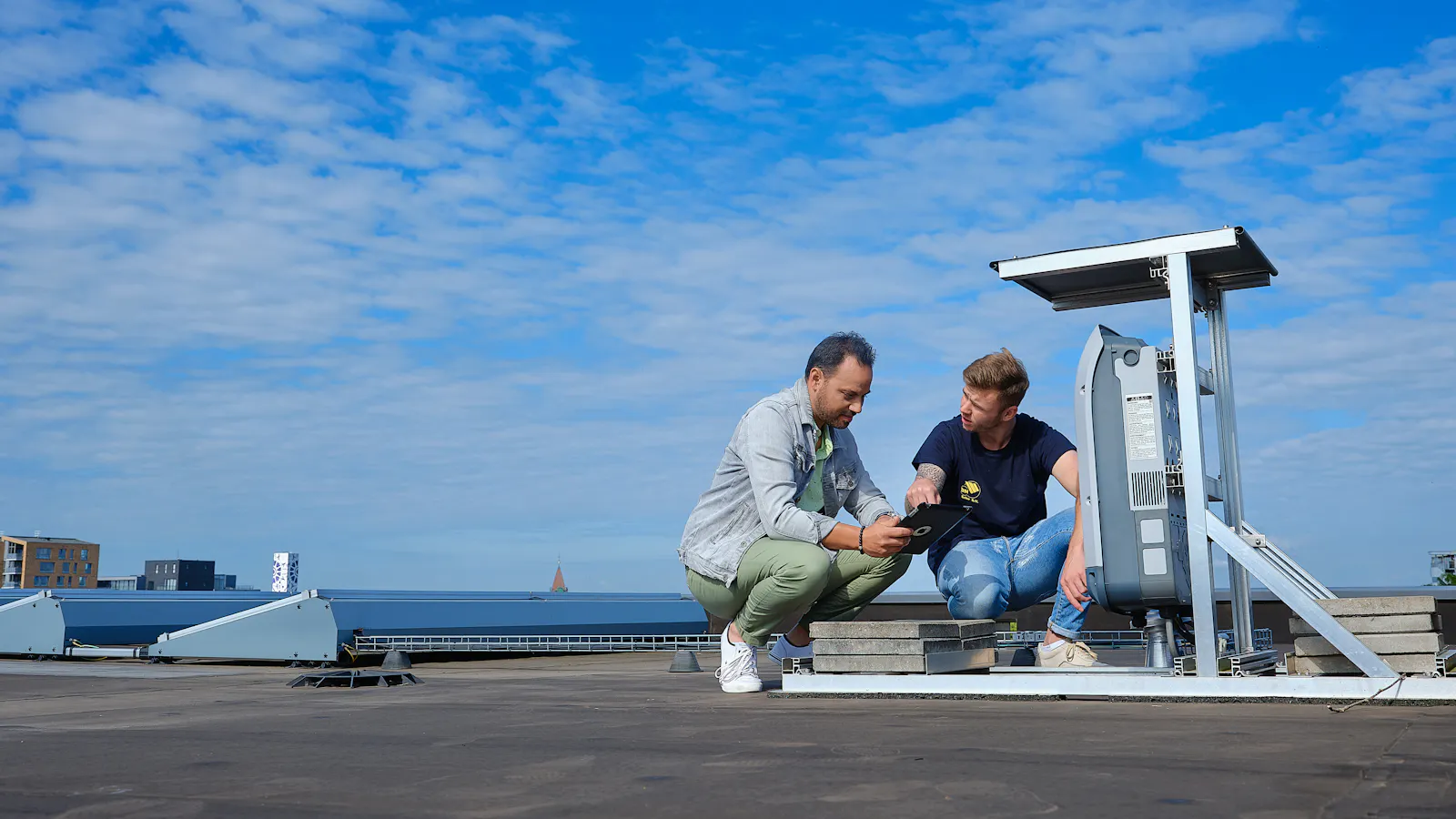 installateur zonnepanelen op dak van appartementencomplex
