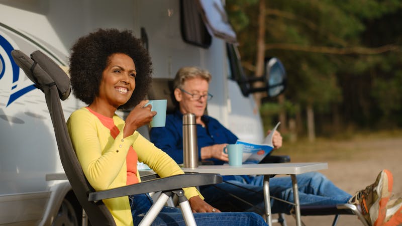 Man en vrouw aan de koffie voor de camper