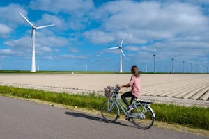 Vrouw fietst langs windmolens