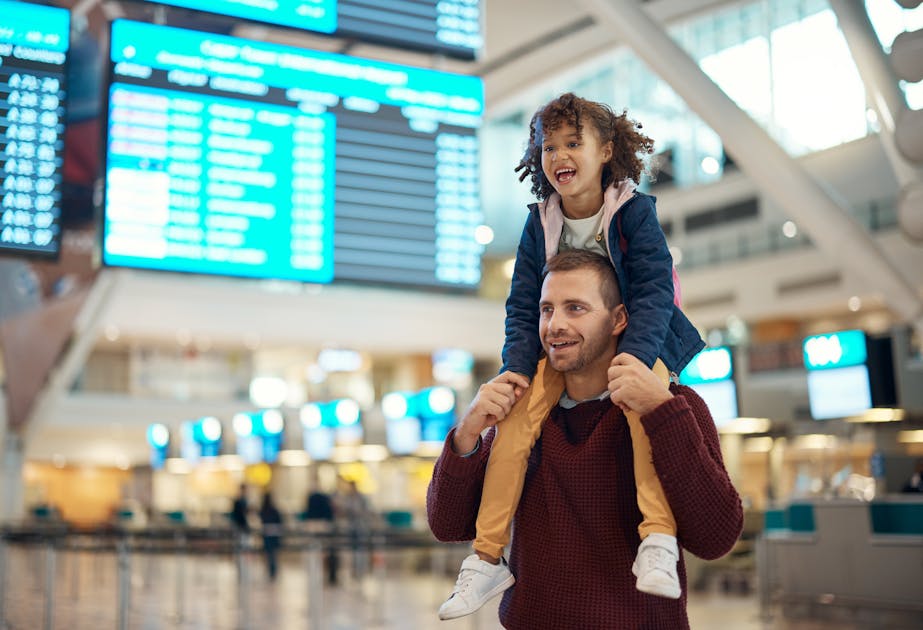 Dochter zit op de schouders van een vader op een vliegveld