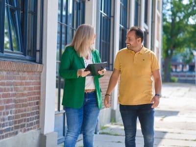Man en vrouw lopen op straat met tablet