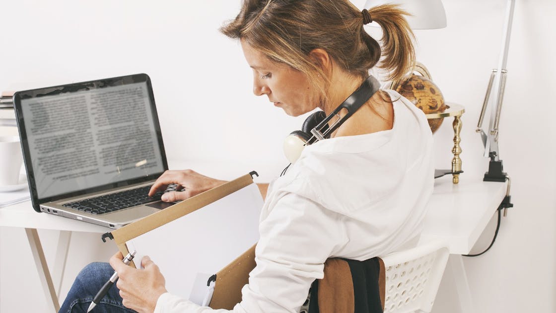 Vrouw zit achter laptop en zoekt in een map. Uw medewerker wordt langdurig ziek. Wat zijn uw risico’s?