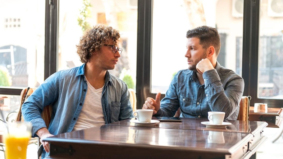 twee mannen aan tafel in een grand café