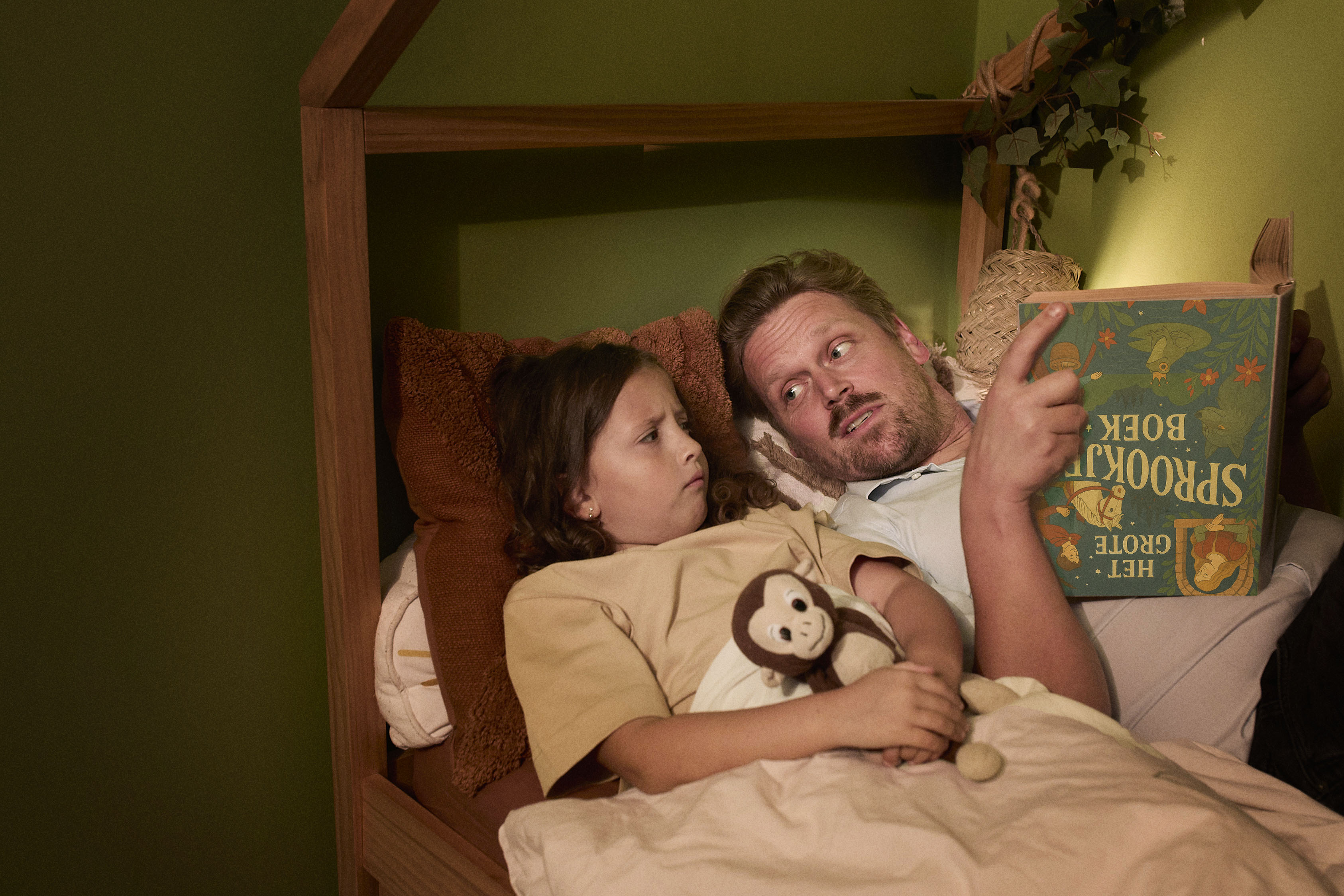 vader leest kind voor en kijkt verschrikt